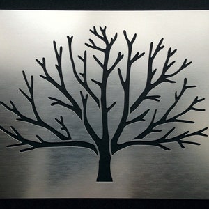 May include: A metal stencil of a bare tree with many branches. The stencil is designed for crafting and decorating projects.