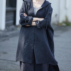 Peut inclure: Une chemise-veste à capuche bleu foncé avec une fermeture boutonnée et des manches longues. La veste est portée sur un haut gris et associée à un pantalon bleu foncé. L'ensemble a un style décontracté.