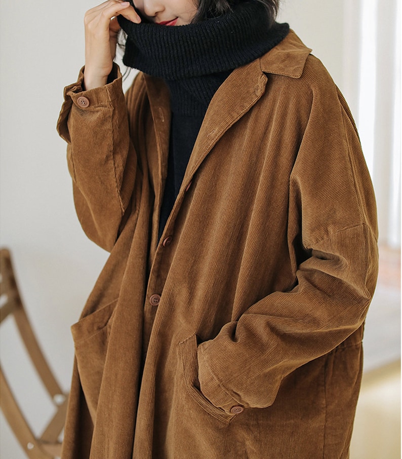 May include: A brown corduroy long-sleeved jacket with a button-up front and two pockets. The jacket has a relaxed fit and a collar.