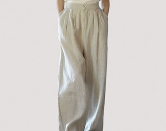 May include: A pair of wide-legged, light beige linen pants with a high waist and pleats. The pants have pockets on the sides and a button closure.