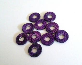 May include: A group of ten purple leather rings with a hole in the center. The rings are arranged in a circular pattern.
