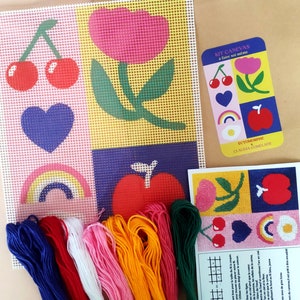 Peut inclure: Kit de canevas avec un motif de grille repr&eacute;sentant une cerise, une fleur, un c&oelig;ur, un arc-en-ciel et une pomme. Comprend une toile, du fil &agrave; broder color&eacute; et des instructions. Le kit est con&ccedil;u pour le bricolage.
