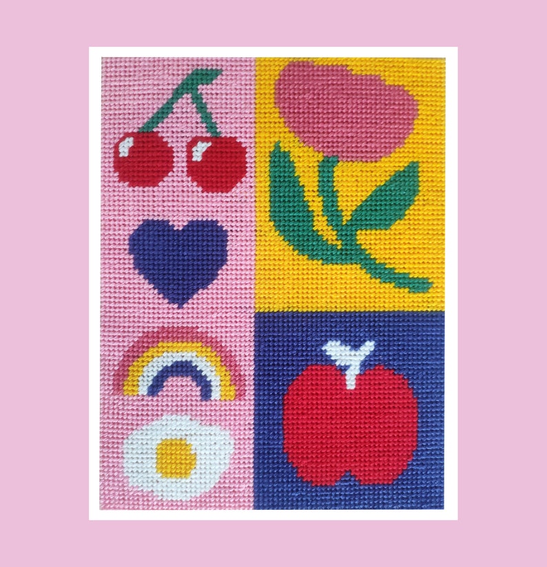 Peut inclure: Une broderie color&eacute;e avec une grille de quatre carr&eacute;s. Les carr&eacute;s pr&eacute;sentent une paire de cerises rouges, une tulipe rose, un c&oelig;ur bleu, un arc-en-ciel, un &oelig;uf au plat et une pomme rouge. Le fond est rose, jaune et bleu.