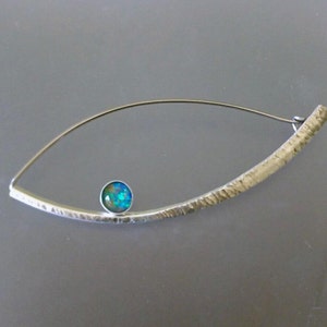 May include: A silver brooch featuring a textured bar and a small, round, iridescent blue opal gemstone.