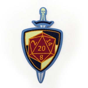 May include: An embroidered patch in blue and white, depicting a shield with a 20-sided die and a sword with a skull at the top. The die shows the numbers 2, 14, 20, and 8.