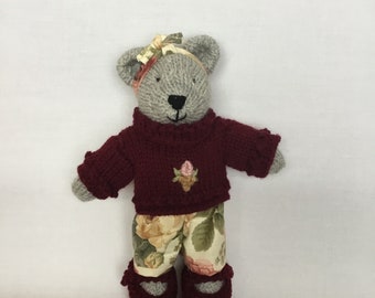 Handmade beige knitted bear, floral trousers and headband, burgundy jumper with embroidered flowers and burgundy shoes.