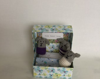 Bunnies in a box , purple and blue theme, floral box and blanket.