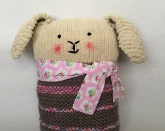 Handmade beige soft plush knitted bunny cushion purple /pink stripe body with pink floral scarf.