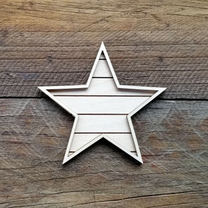 May include: A white wooden star with a rustic woodgrain finish. The star is made of multiple thin strips of wood that are arranged in a horizontal pattern. The star is a decorative item that can be used for a variety of purposes, such as home decor or crafts.