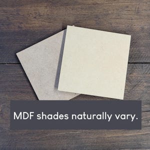 May include: Two square MDF boards in varying shades of beige and gray are displayed on a dark wood surface. The text "MDF shades naturally vary" is at the bottom of the image.
