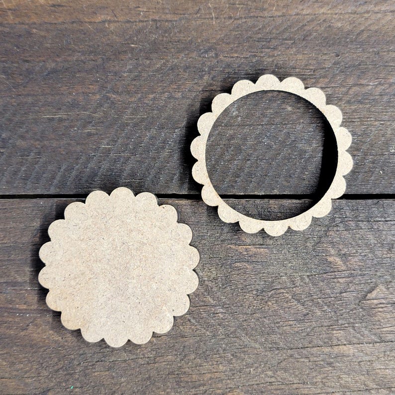 May include: Two unfinished, scalloped-edge wooden circles. One is a solid circle, and the other is a ring. The wood has a light brown color and a natural grain. These craft supplies are ideal for DIY projects and home decor.