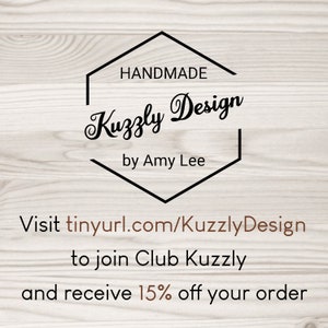 May include: A logo with the text "HANDMADE Kuzzly Design by Amy Lee" inside a black hexagon shape. Below, the text "Visit tinyurl.com/KuzzlyDesign to join Club Kuzzly and receive 15% off your order" is displayed.