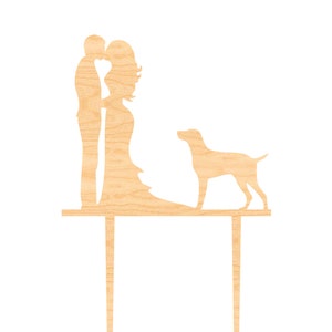 May include: Wooden cake topper featuring a couple kissing and a dog standing beside them. The topper is made of natural wood and is perfect for a wedding or anniversary cake.