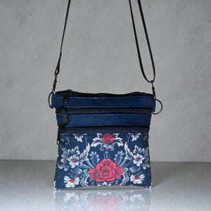 May include: A white ceramic mug with a black handle and the text "But First, Coffee" in a black, handwritten-style font. The mug is on a white surface.