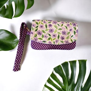 Bolso de mano o billetera de tamaño perfecto con bolsillos con correa para la muñeca y compartimento con cremallera. Regalo para menores de 25 años para su tela de flores y puntos de color púrpura.