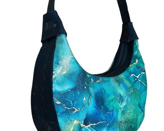 May include: A crescent-shaped handbag with a black strap and a blue and gold marbled design.