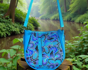 May include: A turquoise shoulder bag with a floral pattern in shades of blue, purple, and black. The bag has a zippered closure and a long, adjustable strap. The bag is made of a durable material and is suitable for everyday use.