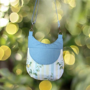 Zuri Crossbody Bag with ample space featuring front slip pocket under a flap and zippered main compartment. In vintage print cotton an denim