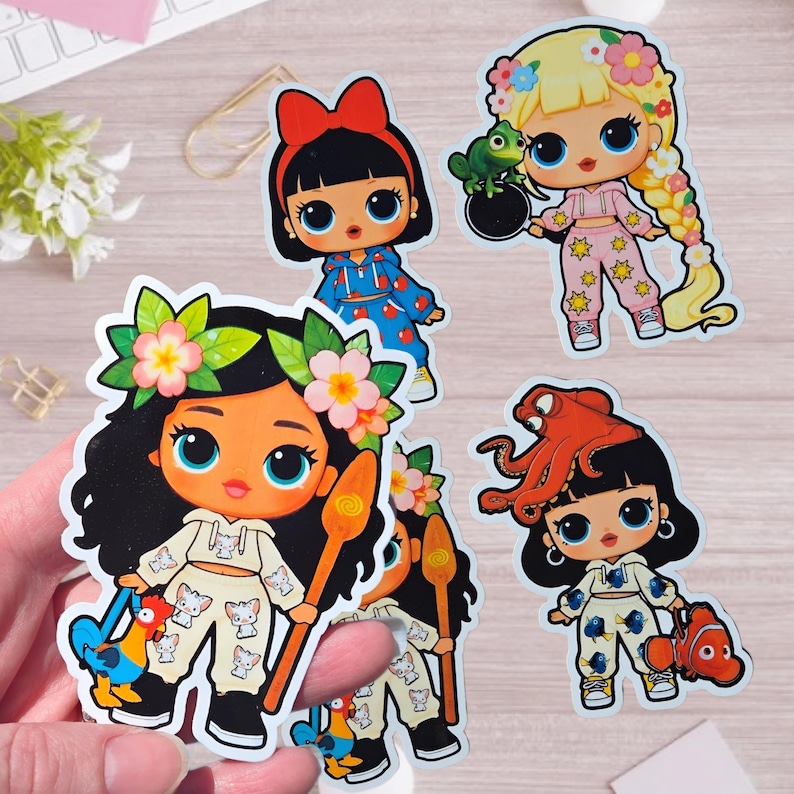May include: A collection of four die-cut vinyl stickers featuring stylized cartoon characters with large eyes. The designs include characters inspired by Moana, Rapunzel, and Dory, wearing matching crop top and pant sets with various character-themed prints.