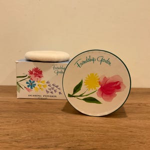 May include: A vintage dusting powder set with a box and a round container. The box features floral illustrations and the text "Friendship Garden" and "Dusting Powder". The round container has a floral design and the words "Friendship Garden".