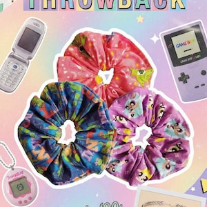 May include: A colourful collage with a flip phone, Game Boy Color, Tamagotchi, and three scrunchies. The text reads "Millennial Throwback" and "The Ultimate '90s Hair Accessory is BACK!"