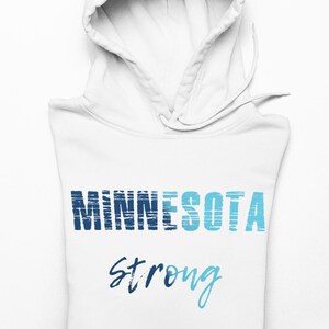 May include: White hooded sweatshirt with the words "MINNESOTA" in blue and light blue, and the word "strong" in blue script. The hoodie is folded, with the hood up.