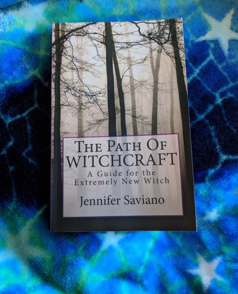Puede incluir: Un libro titulado "The Path of Witchcraft: A Guide for the Extremely New Witch" de Jennifer Saviano. La portada presenta una fotograf&iacute;a en blanco y negro de un bosque brumoso.