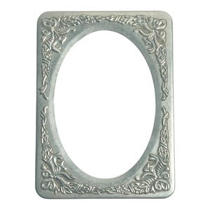 May include: A silver-colored, rectangular picture frame with an oval opening. The frame is adorned with ornate, raised floral and scrollwork designs in each corner and along the sides, creating a decorative border.