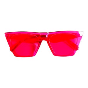 May include: Vibrant red sunglasses with a geometric frame. The lenses and frame are a transparent red. The sunglasses have a modern, bold design, ideal for adding a pop of colour to any outfit. The frame is angular.
