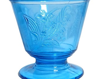 Niebieski szklany przedmiot widoczny na zdjęciu to prawdopodobnie cukierniczka z wzorem „Róża w śniegu”, wyprodukowana dla L.G. Wright Glass przez innego producenta