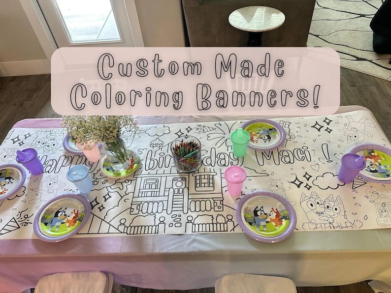 May include: A white tablecloth with a black and white coloring page design featuring a house, palm trees, and the words "Happy Birthday Maci!"  The tablecloth is set with colorful plastic cups and plates.  The text "Custom Made Coloring Banners!" is written in pink on a white background.