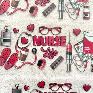 May include: A pink and white patterned background with various pink and white stickers. The stickers include a stethoscope, a coffee cup, a pair of glasses, a syringe, a blood bag, a pill bottle, a watch, and a pair of clogs. The text "NURSE LIFE" is in pink letters.