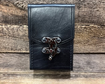May include: Black leather wallet with a silver clasp and decorative studs.