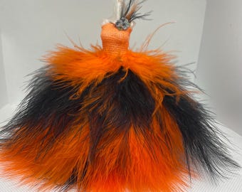 May include: A black and orange feather dress with a small flower accent on the bodice.