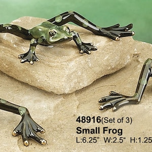 May include: Set of three green and black ceramic frog figurines. Each frog is posed in a different position. The frogs are approximately 6.25 inches long, 2.5 inches wide, and 1.25 inches high.
