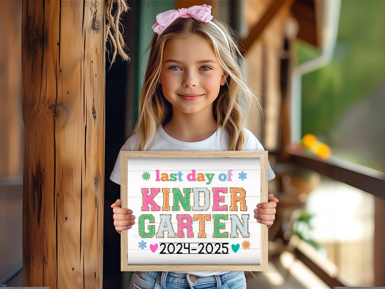 May include: A girl holds a sign that says "last day of kindergarten 2024-2025" in colorful letters with a white background. The sign has a wooden frame.