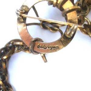 May include: A gold-toned chain necklace with a clasp that reads "Adele Simpson".