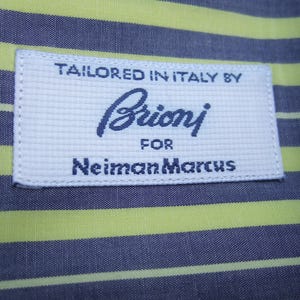 May include: White label with black text that reads "Tailored in Italy by Brioni for Neiman Marcus".