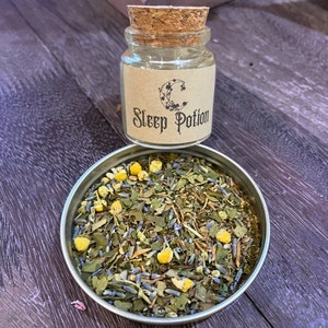 May include: A small glass jar with a cork lid filled with dried herbs and flowers. The jar has a brown paper label that says "Sleep Potion".