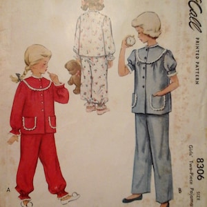 May include: Vintage McCall's sewing pattern for girls' two-piece pajamas. The pattern shows two girls wearing different styles of pajamas, one in red and one in blue. The pattern number is 8306 and the size is 4. The price is 25 cents.