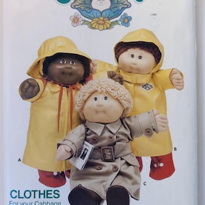 May include: Vintage Butterick sewing pattern featuring Cabbage Patch Kids dolls. The pattern cover displays three dolls, two in yellow raincoats and one in a tan trench coat. The text "CLOTHES For your Cabbage Patch Kids!" is visible.