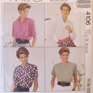 May include: McCall's sewing pattern envelope featuring four different blouse designs. The designs include a pink button-down, a white button-down, a patterned top, and a striped top. The envelope includes the text "Woman's Day Collection" and "Cut-to-Fit".