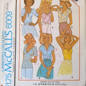 May include: Vintage McCall's 6009 sewing pattern for Misses' tops. The envelope features illustrations of various top styles, including a light blue top, a pink top, and a yellow top. The pattern is for stretch knit fabrics.