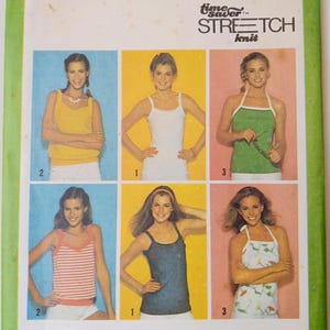 May include: Vintage Simplicity sewing pattern 9035 featuring a variety of knit tops. The pattern includes images of different styles, such as tank tops and halter tops, in various colors. The cover has text that reads "Simplicity" and "Stretch Knit".