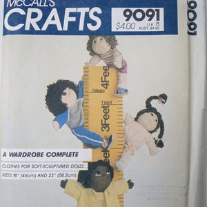 May include: McCall's Crafts 9091 sewing pattern envelope for soft-sculptured dolls in 18-inch and 23-inch sizes. The cover features four dolls of varying appearances interacting with a large yellow ruler graphic labeled with feet and meters.