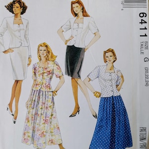 May include: McCall's sewing pattern featuring illustrations of women's suits and separates. The pattern includes a white suit, a white top with a black skirt, a floral print dress, and a blue polka dot skirt and top. The pattern number is 6411.
