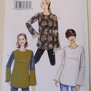May include: A sewing pattern for Very Easy Vogue tops, featuring three different designs. The pattern includes sizes A5 (6-8-10-12-14). The tops have long sleeves and various color block and floral patterns.
