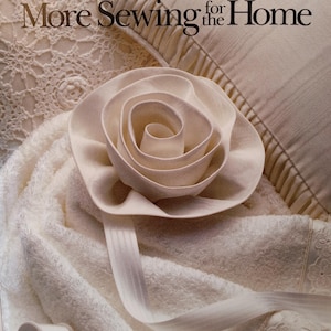 May include: A book titled "More Sewing for the Home" with a white rose made of fabric on the cover. The book is part of the Singer Sewing Reference Library.