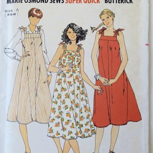 May include: A Butterick sewing pattern envelope, number 6048, featuring Marie Osmond. The illustration displays three variations of a sleeveless dress with tie-shoulder straps, including a striped version, a floral print, and a solid red dress.