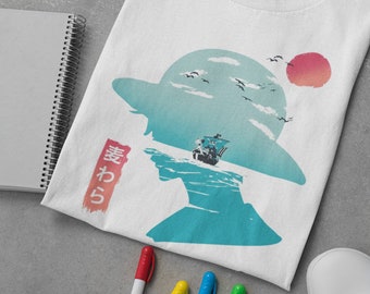 Könnte beinhalten: Weißes T-Shirt mit einer blauen und weißen Silhouette einer Person, die einen Strohhut trägt. Die Silhouette ist vor einem blauen und weißen Himmel mit einer roten Sonne und weißen Vögeln platziert. Der japanische Text "おれ" ist in Rot auf der linken Seite des Shirts geschrieben.